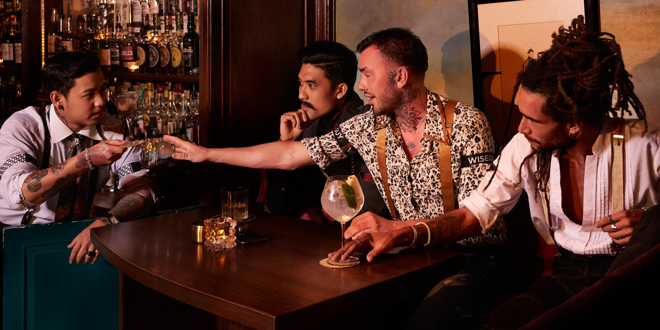 Four men in a bar, all of them are wearing Wiseguy Original Suspenders and Sleeve Garters